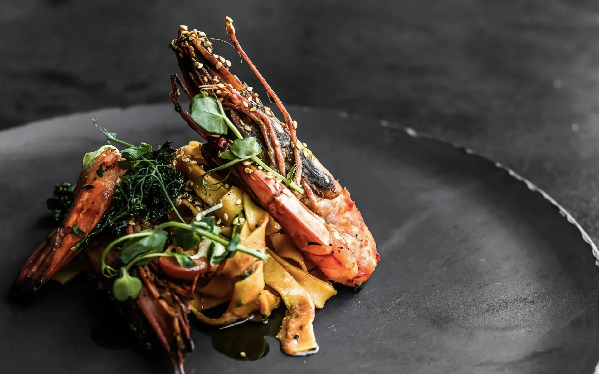 Der Salnerhof – das Hotel in Ischgl Garnelen auf Pasta mit grünen Kräutern auf schwarzem Teller
