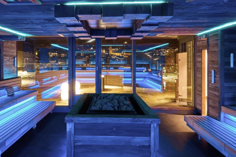 Ihr Skihotel in Ischgl Moderne Sauna mit blauer LED-Beleuchtung und Blick auf Stadt bei Nacht