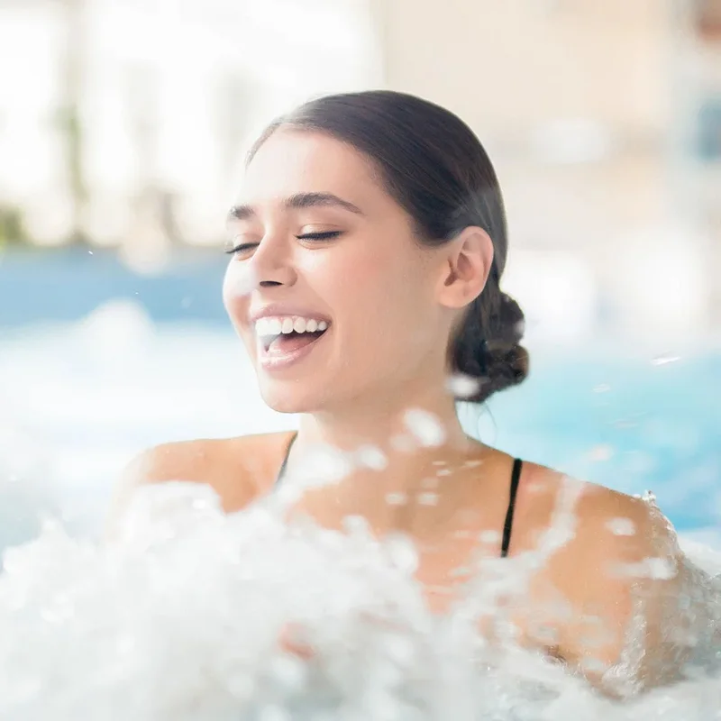 Ihr Wellnesshotel in Ischgl | Das Spa im Salnerhof Frau entspannt lachend im sprudelnden Whirlpool