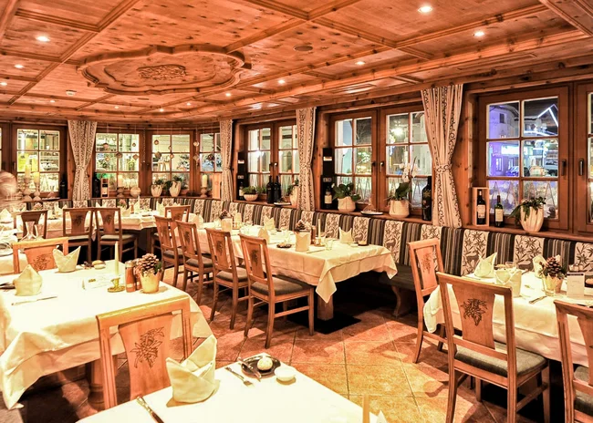 Ihr liebstes Restaurant in Ischgl Gemütliches Restaurant mit Holzmöbeln und gedeckten Tischen bei Nacht