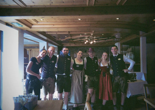 Dein Job im Salnerhof Gruppe von sieben Hotelmitarbeitern in traditioneller Tracht in einem Restaurant