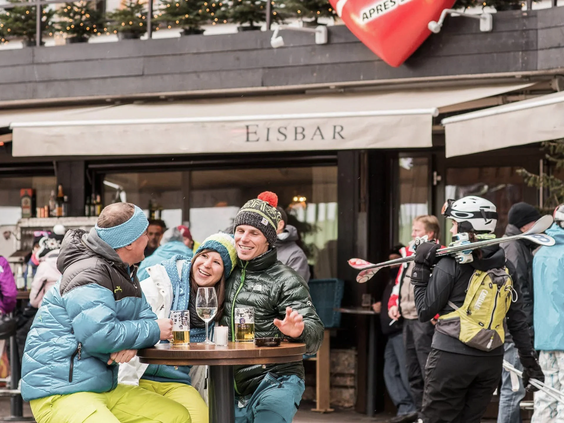Die Bilder aus dem Hotel Salnerhof Menschen in Winterkleidung sitzen und stehen vor einer Eisbar mit Getränken