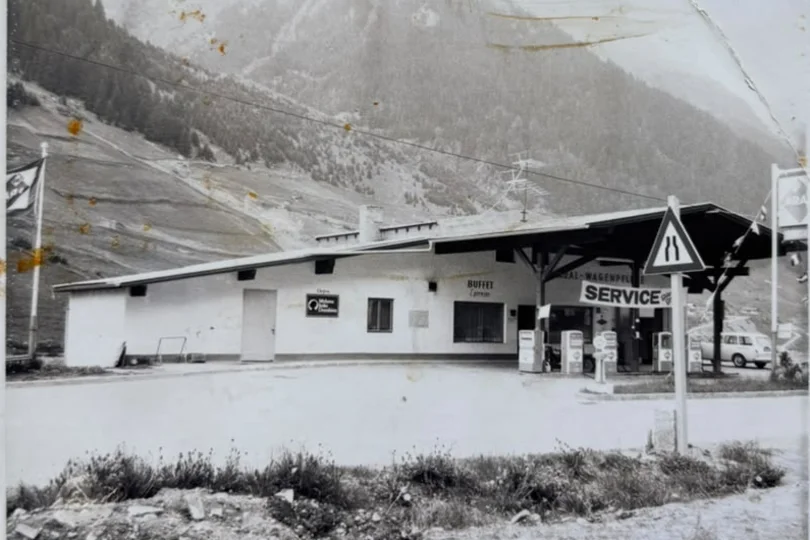 The history of Salnerhof Black and white photo of an old gas station with mountains in the background