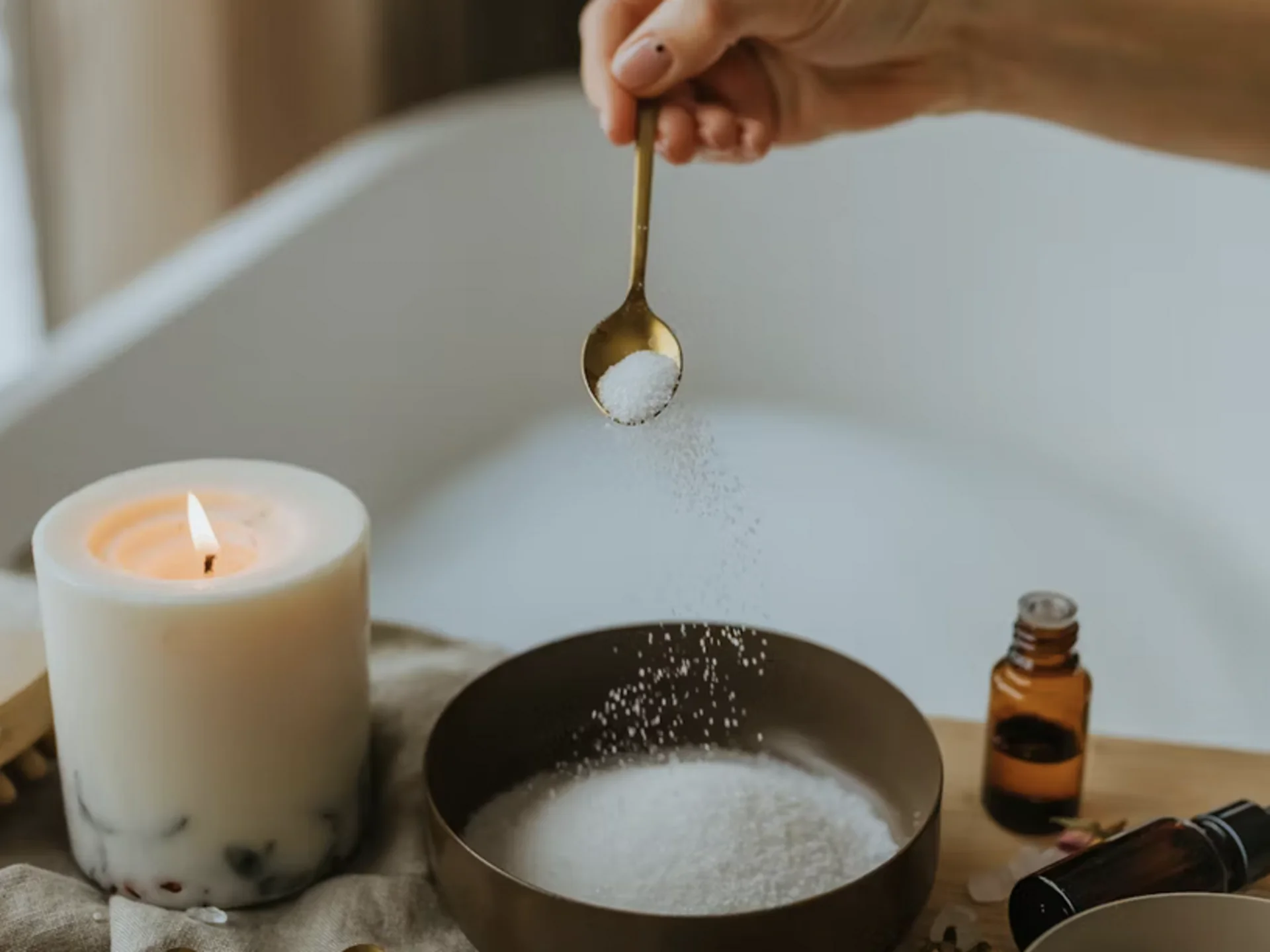 Die Bilder aus dem Hotel Salnerhof Hand streut Salz in Schale mit Spa-Zutaten und brennender Kerze