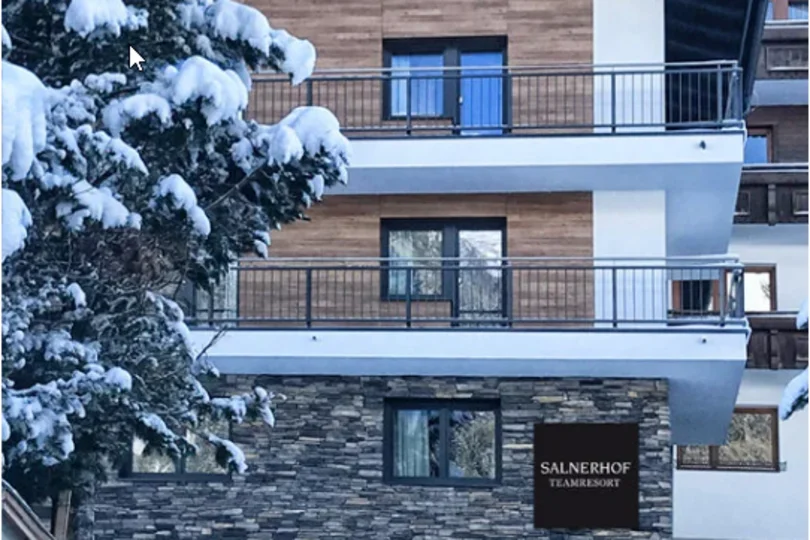 Dein Job im Salnerhof Verschneiter Baum vor dem Salnerhof Teamresort mit Holz- und Steinfassade