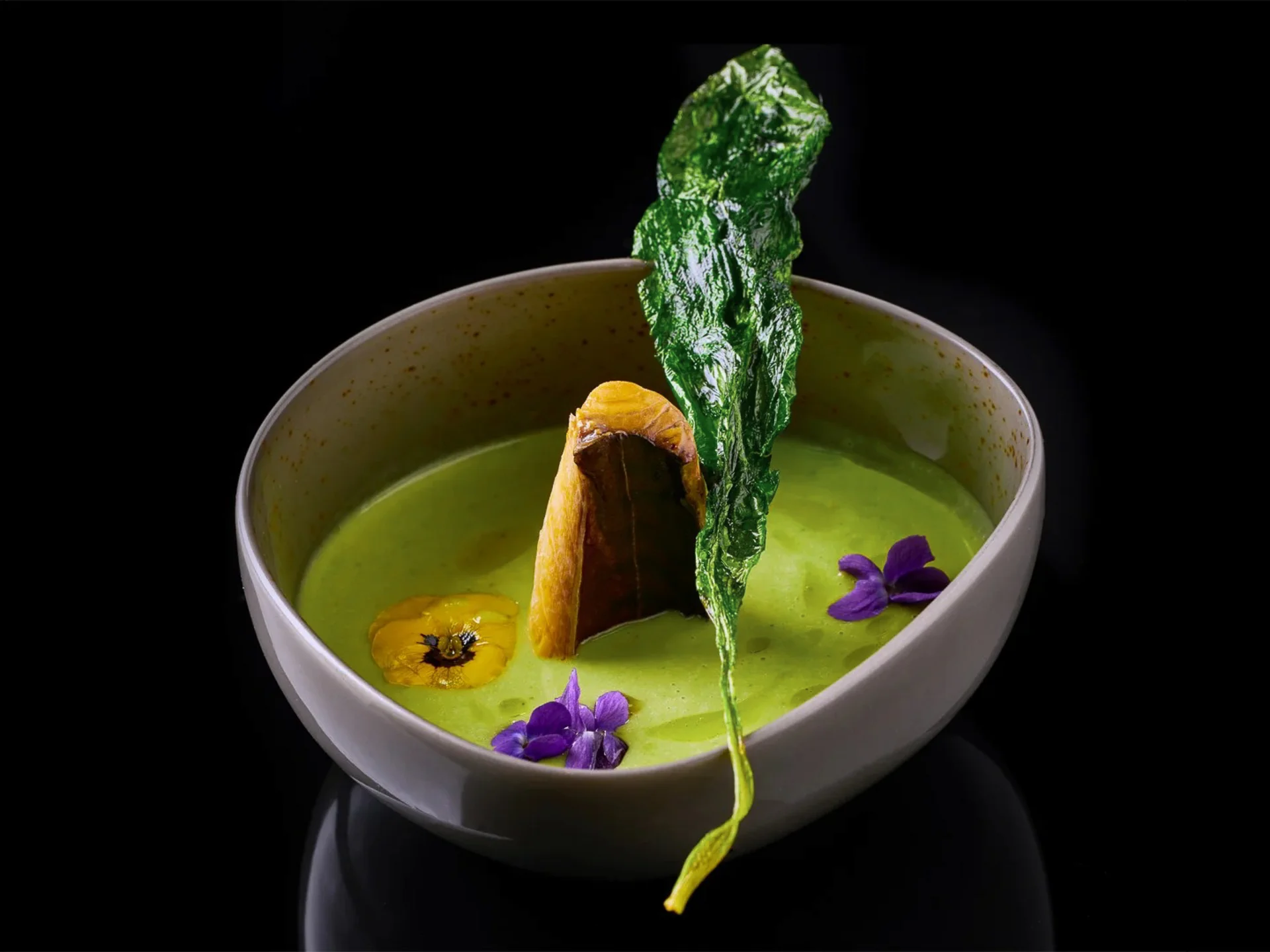 Die Bilder aus dem Hotel Salnerhof Grüne cremige Suppe mit essbaren Blüten und knusprigem Blatt in weißer Schale