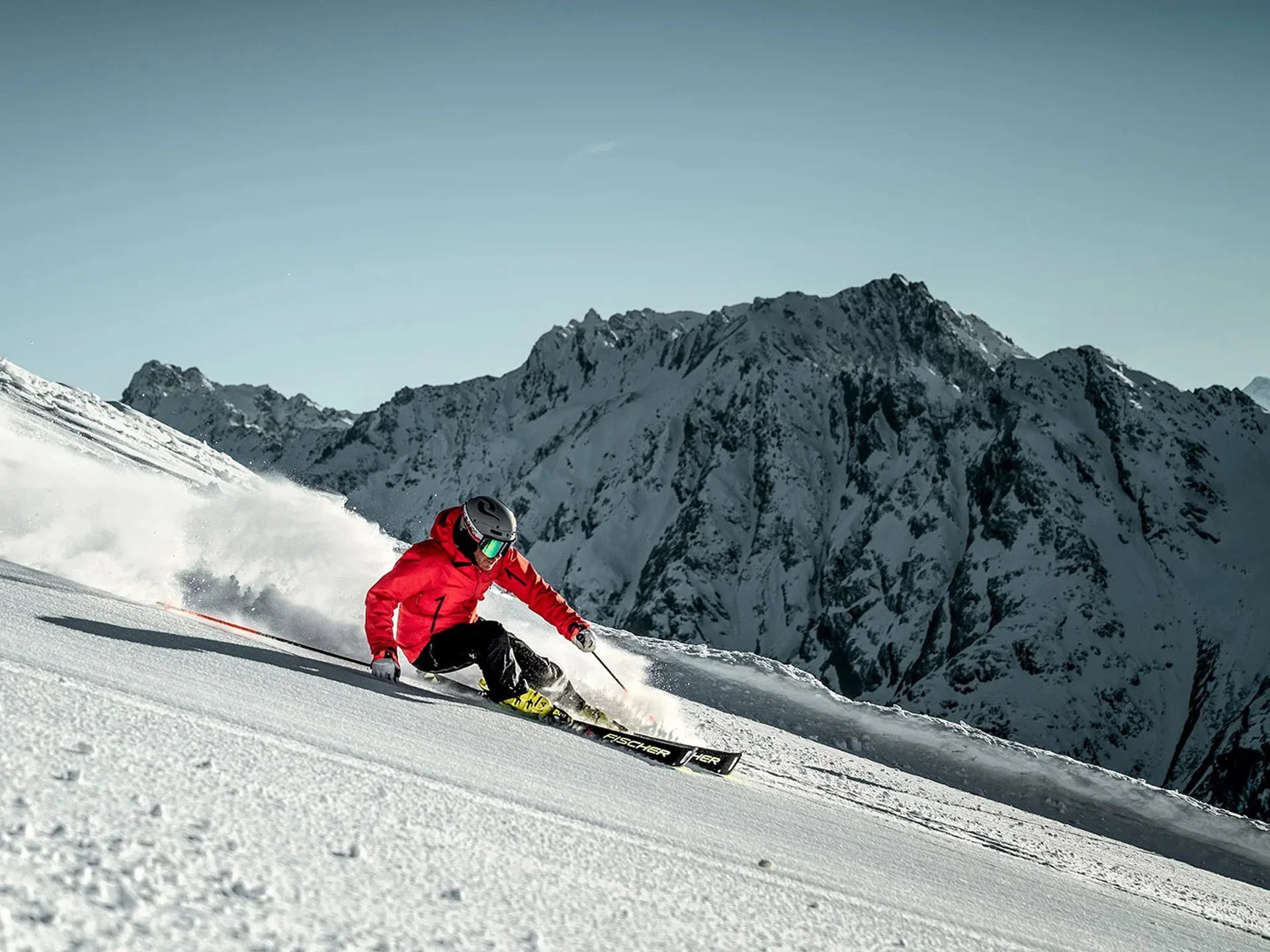 Die Bilder aus dem Hotel Salnerhof Skifahrer in roter Jacke fährt auf schneebedecktem Hang vor Bergkulisse
