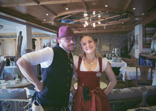 Dein Job im Salnerhof Zwei lächelnde Hotelangestellte in traditioneller Tracht im Restaurant