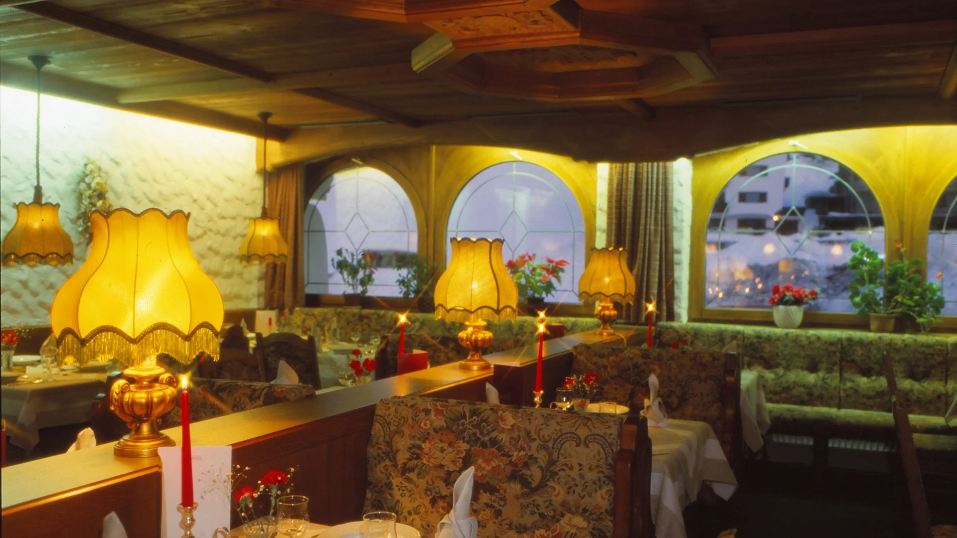 Die Geschichte des Salnerhofs Gemütliches Restaurant mit warmem Licht, dekorierten Tischen und floralen Polstern