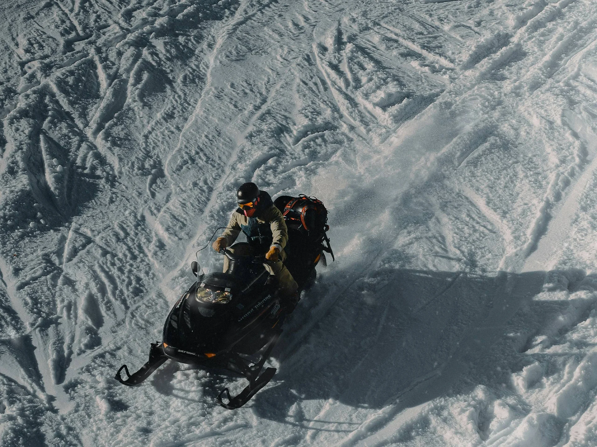 Die Bilder aus dem Hotel Salnerhof Person fährt mit schwarzem Schneemobil über verschneite, gespurtte Fläche