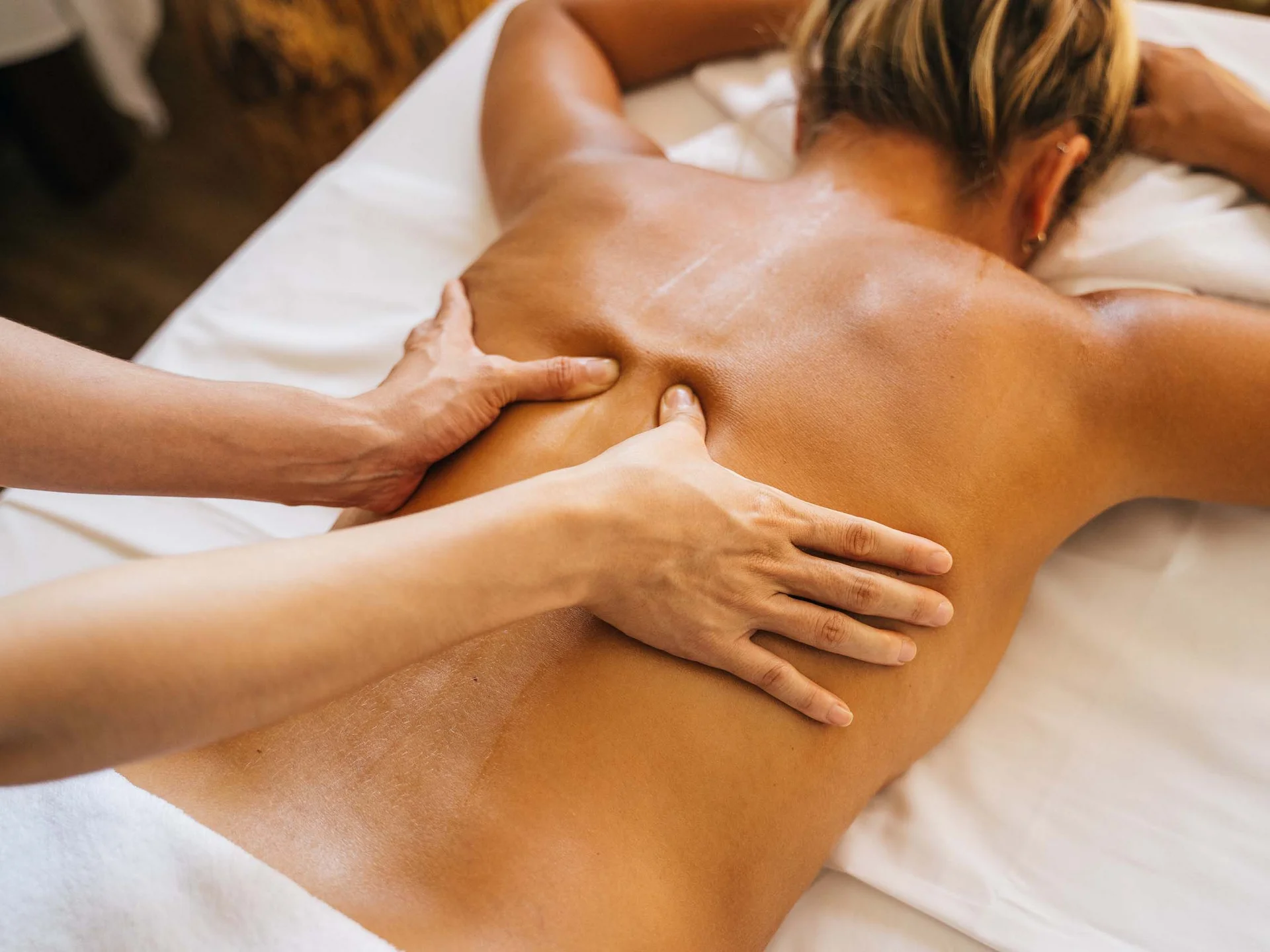 Die Bilder aus dem Hotel Salnerhof Person erhält Rückenmassage auf weißer Liege