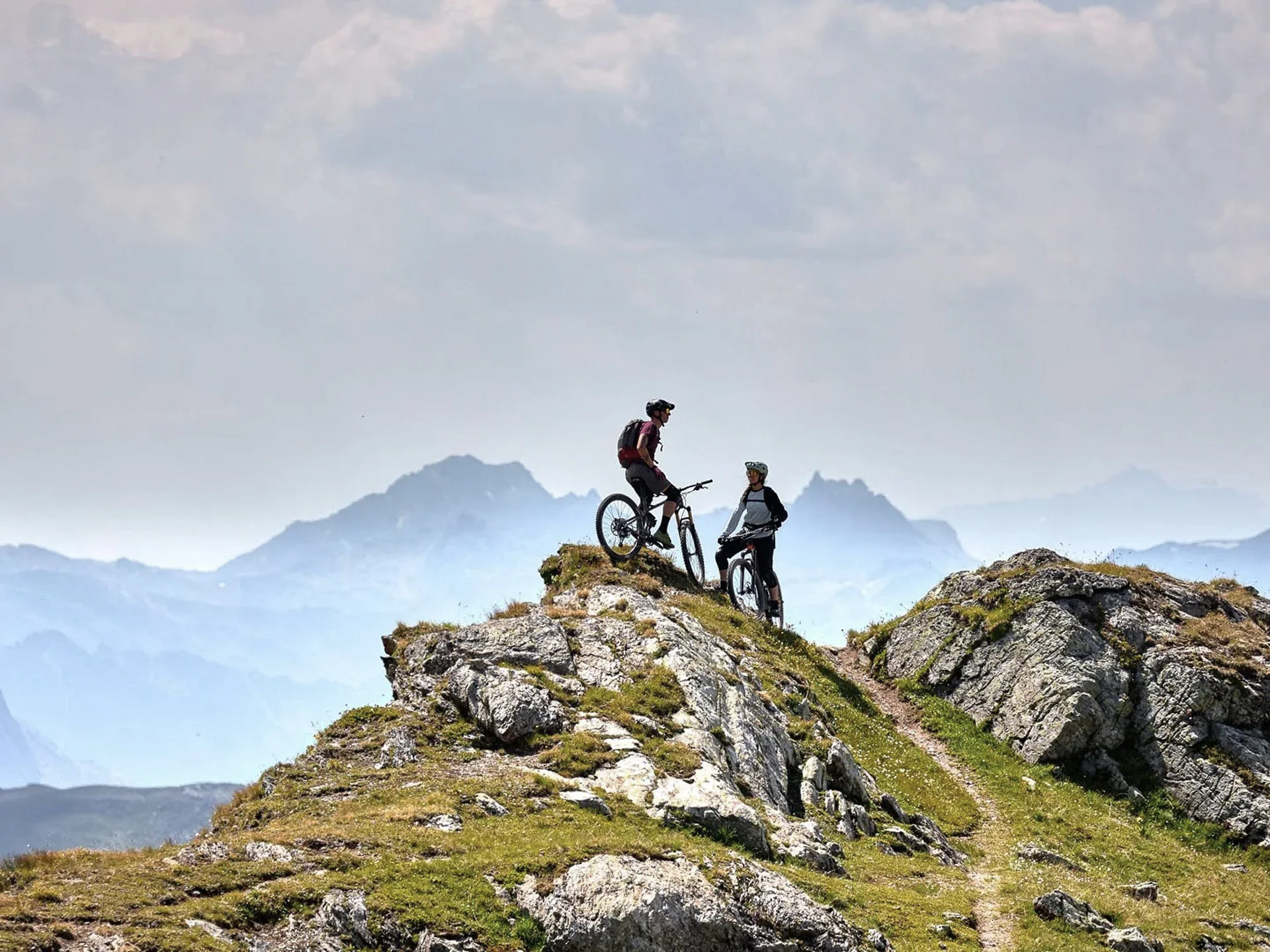 Die Bilder aus dem Hotel Salnerhof Zwei Mountainbiker stehen mit ihren Fahrrädern auf einem felsigen Berggipfel