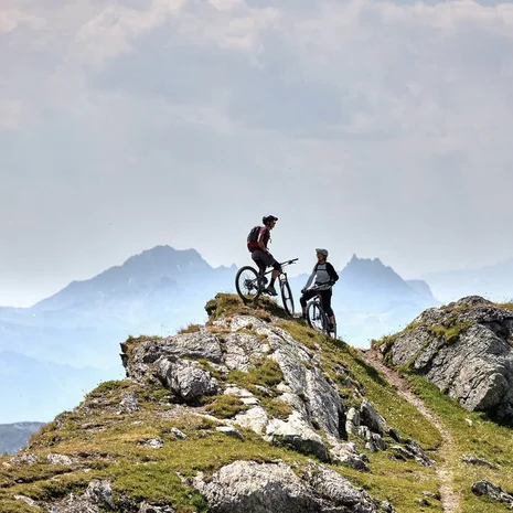 Der Salnerhof – das Hotel in Ischgl Zwei Mountainbiker stehen mit ihren Fahrrädern auf einem felsigen Berggipfel