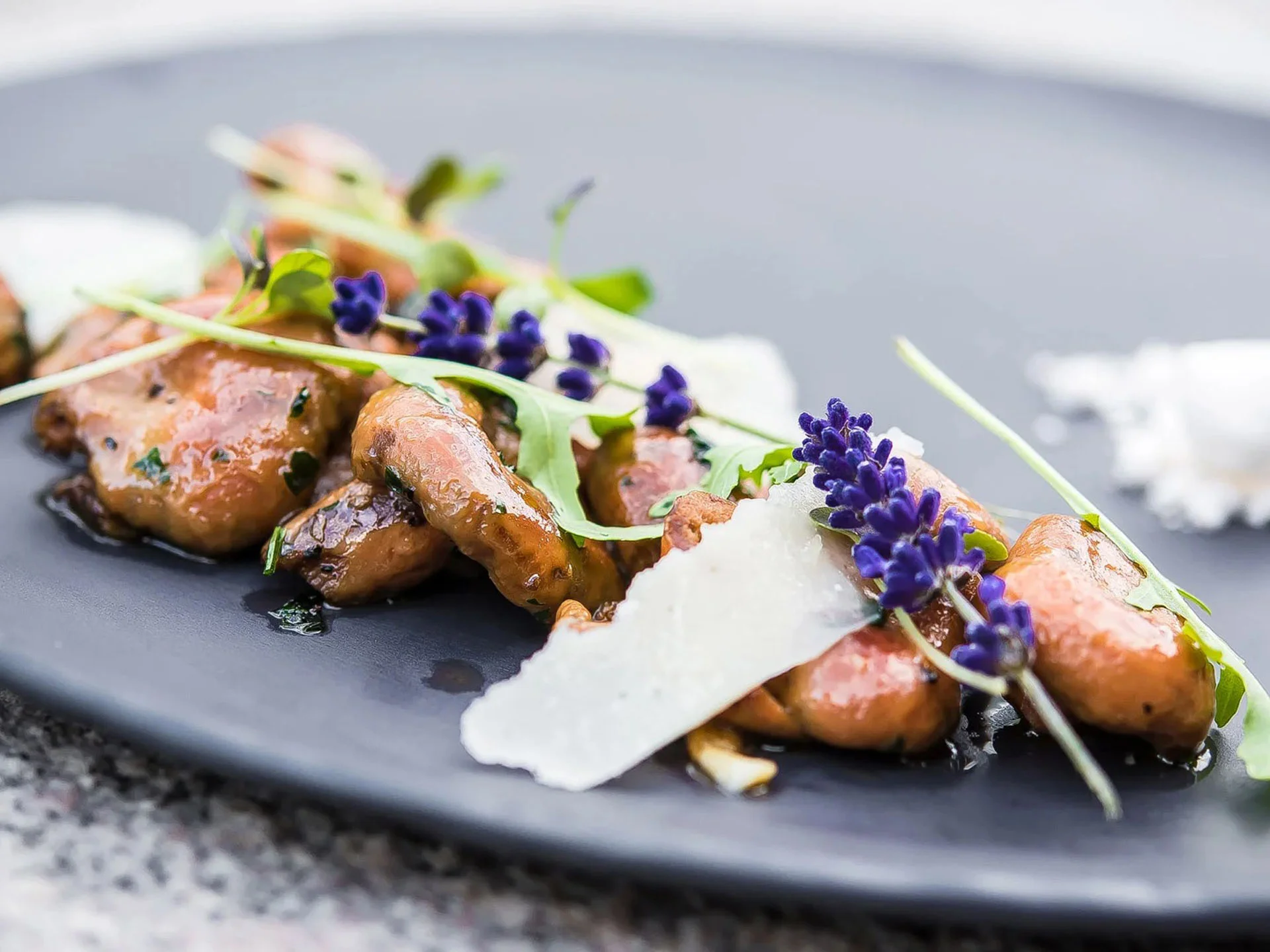 Die Bilder aus dem Hotel Salnerhof Gourmetgericht mit Pilzen, Parmesan, Rucola und Lavendel auf schwarzem Teller
