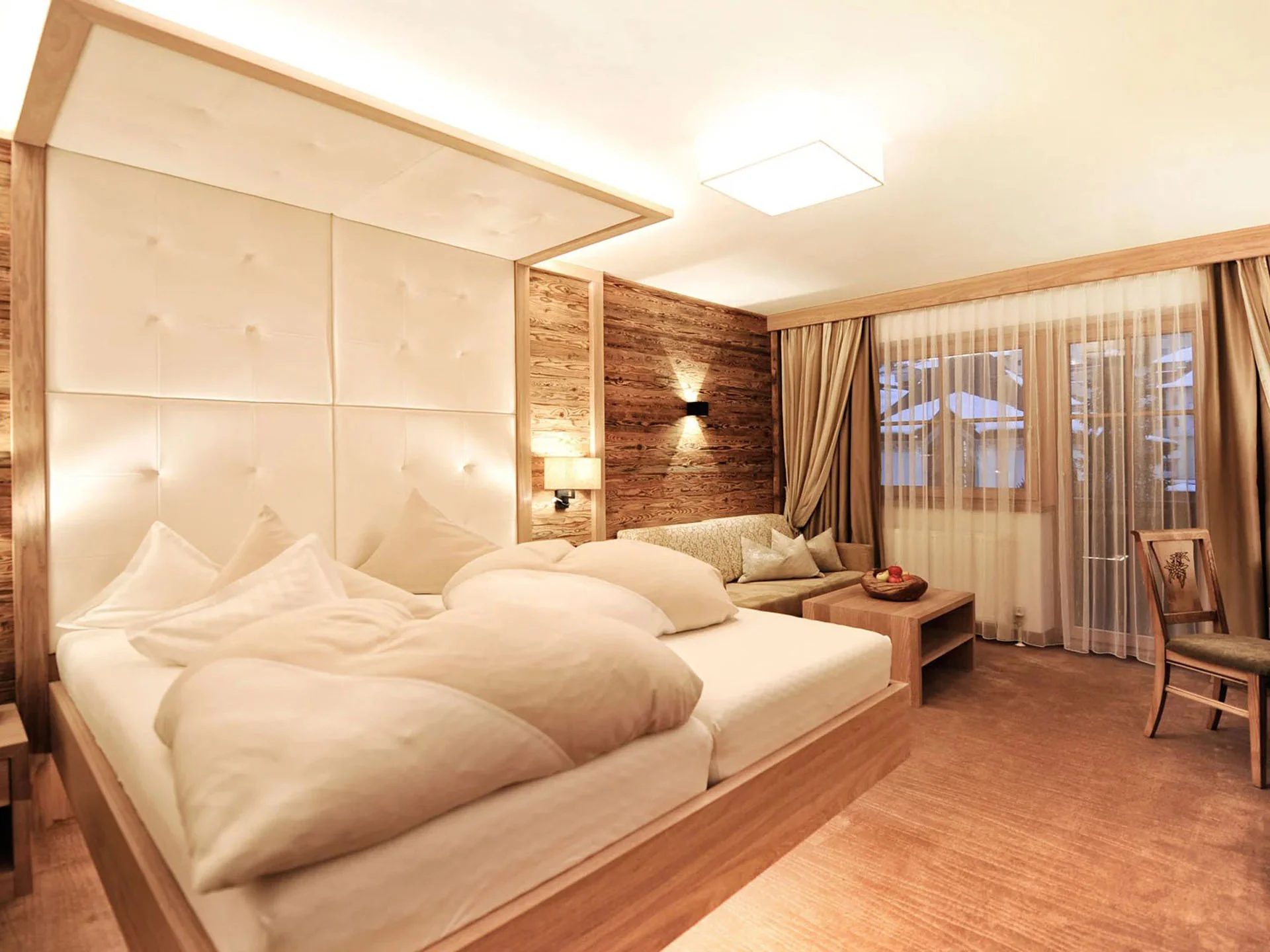 Die Bilder aus dem Hotel Salnerhof Gemütliches Hotelzimmer mit großem Bett, Sofa, Schreibtisch und Vorhängen