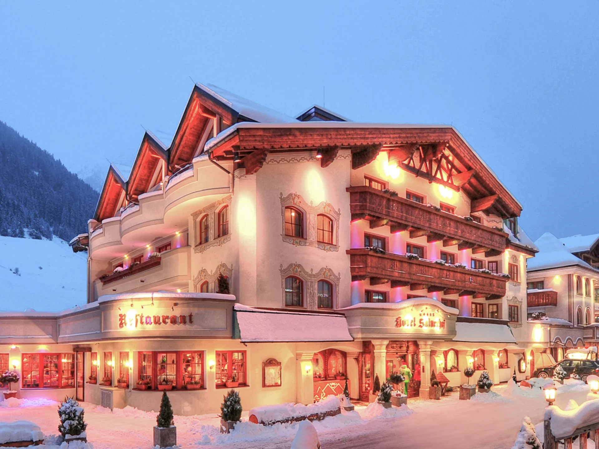 Die Bilder aus dem Hotel Salnerhof Beleuchtetes Hotel in verschneiter Berglandschaft bei Dämmerung