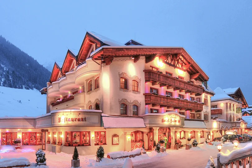 Dein Job im Salnerhof Beleuchtetes Hotel in verschneiter Berglandschaft bei Dämmerung