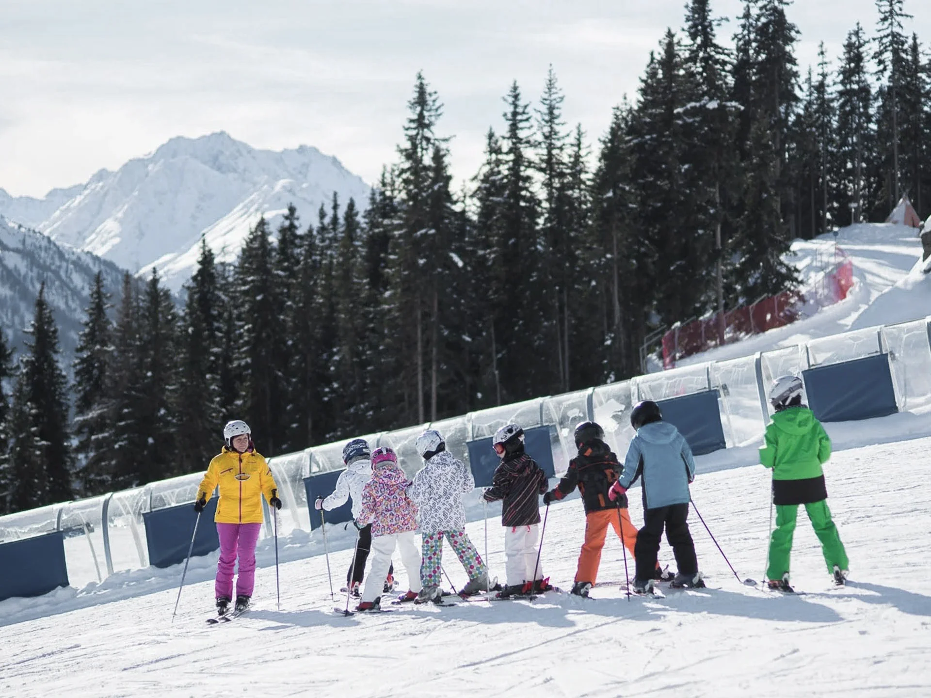 Die Bilder aus dem Hotel Salnerhof Skilehrer mit Kindern beim Skikurs auf schneebedeckter Piste vor Bergkulisse