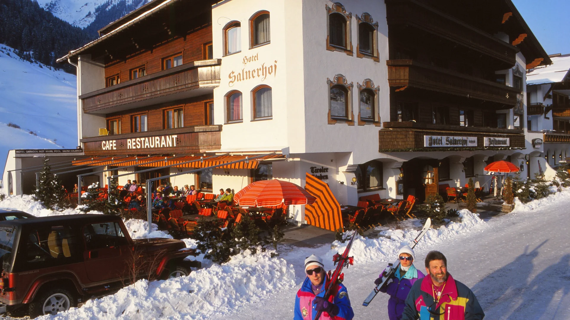 Die Geschichte des Salnerhofs Hotel mit Café und Restaurant im Schnee mit Skifahrern vor dem Gebäude