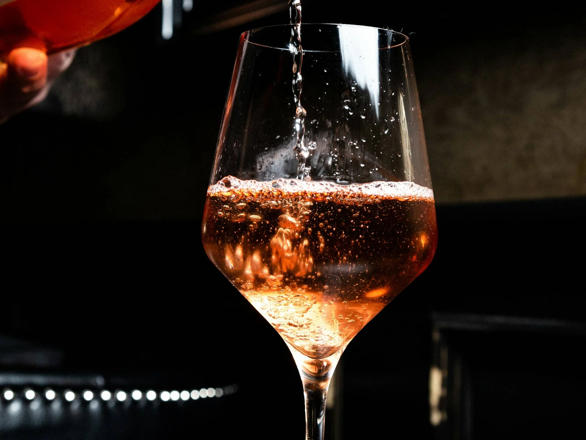 Die Bilder aus dem Hotel Salnerhof Roséwein wird aus einer Flasche in ein Weinglas eingeschenkt