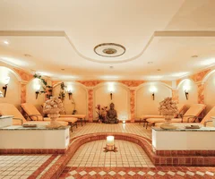 Ihr Wellnesshotel in Ischgl | Das Spa im Salnerhof Entspannungsraum mit Liegestühlen, Kerze und Statuen in warm beleuchtetem Spa