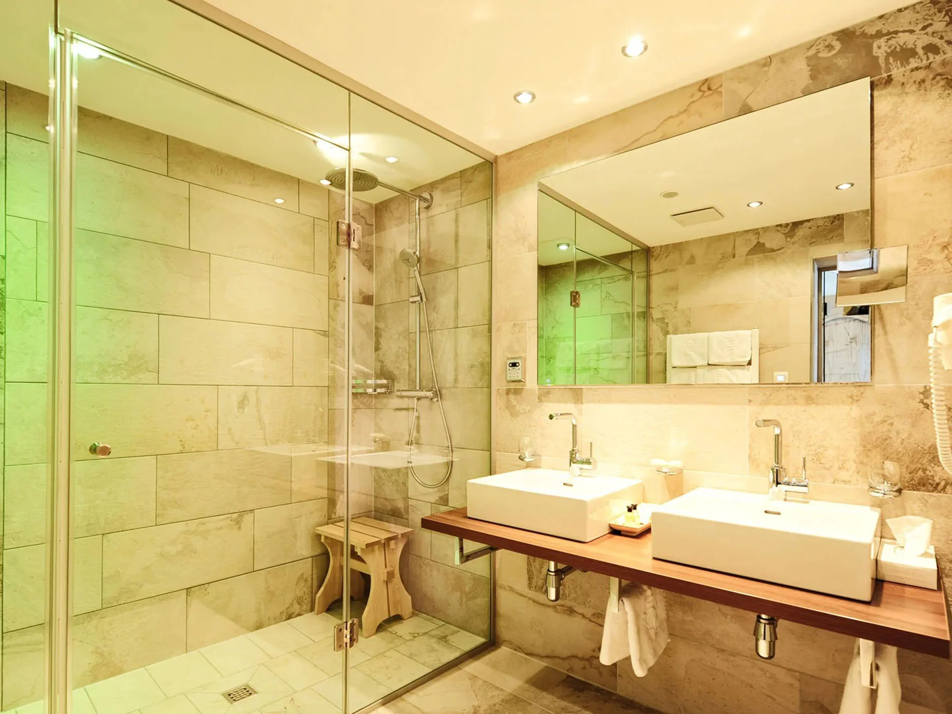 Die Bilder aus dem Hotel Salnerhof Modernes Badezimmer mit Doppelwaschbecken und Glastür zur Dusche