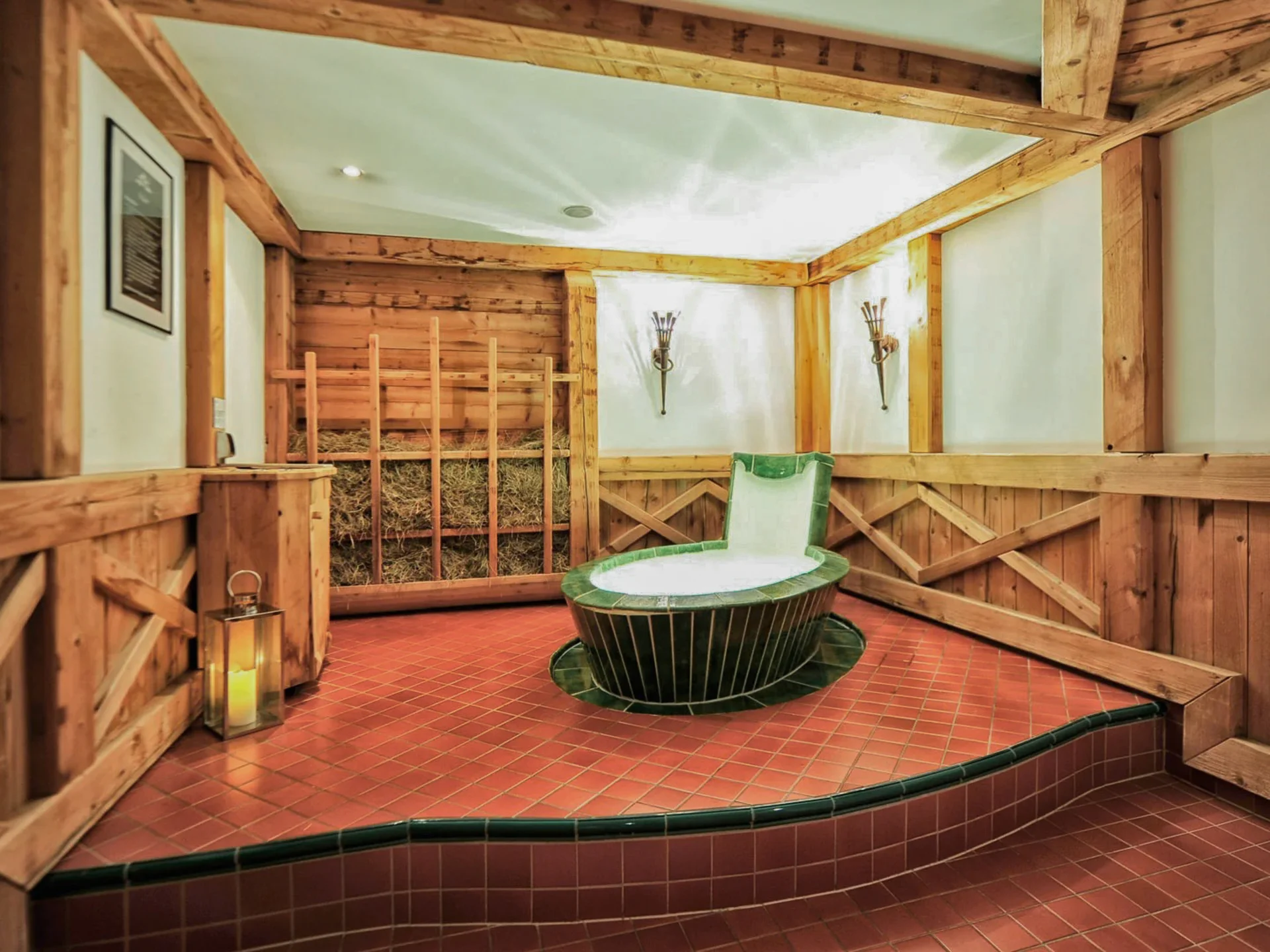Die Bilder aus dem Hotel Salnerhof Gemütlicher Wellnessbereich mit Holzverkleidung und einer grünen Wellnessliege