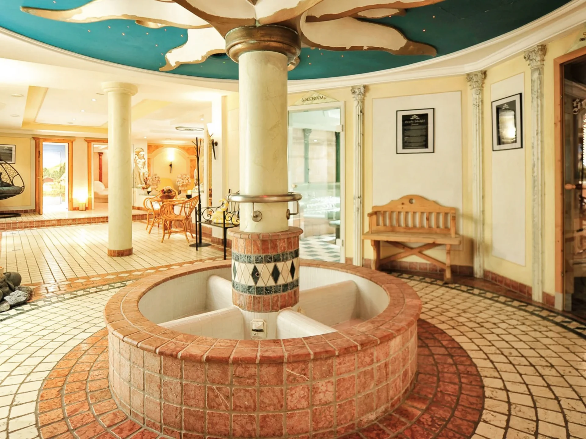 Die Bilder aus dem Hotel Salnerhof Heller Wellnessbereich mit Buddha-Statue, Sitzbank und Saunaeingang