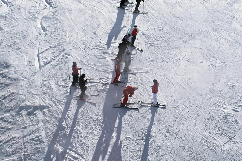 Silvretta Skigebiet Gruppe von Skifahrern auf verschneiter Piste mit langen Schatten