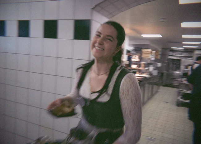 Dein Job im Salnerhof Lächelnde Frau in traditioneller Tracht in einer Küche mit Teller in der Hand