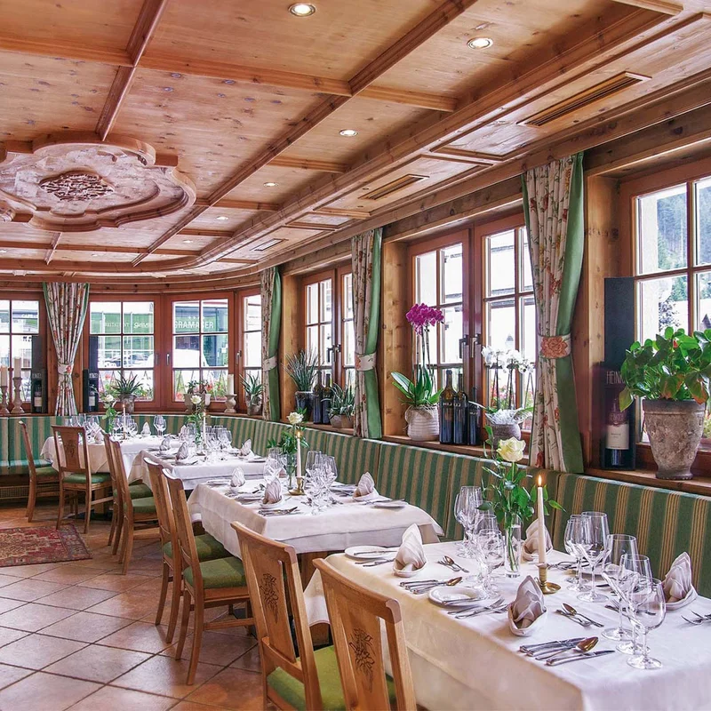 Ihr liebstes Restaurant in Ischgl Gemütlicher Restaurantbereich mit Holzmöbeln und eingedeckten Tischen