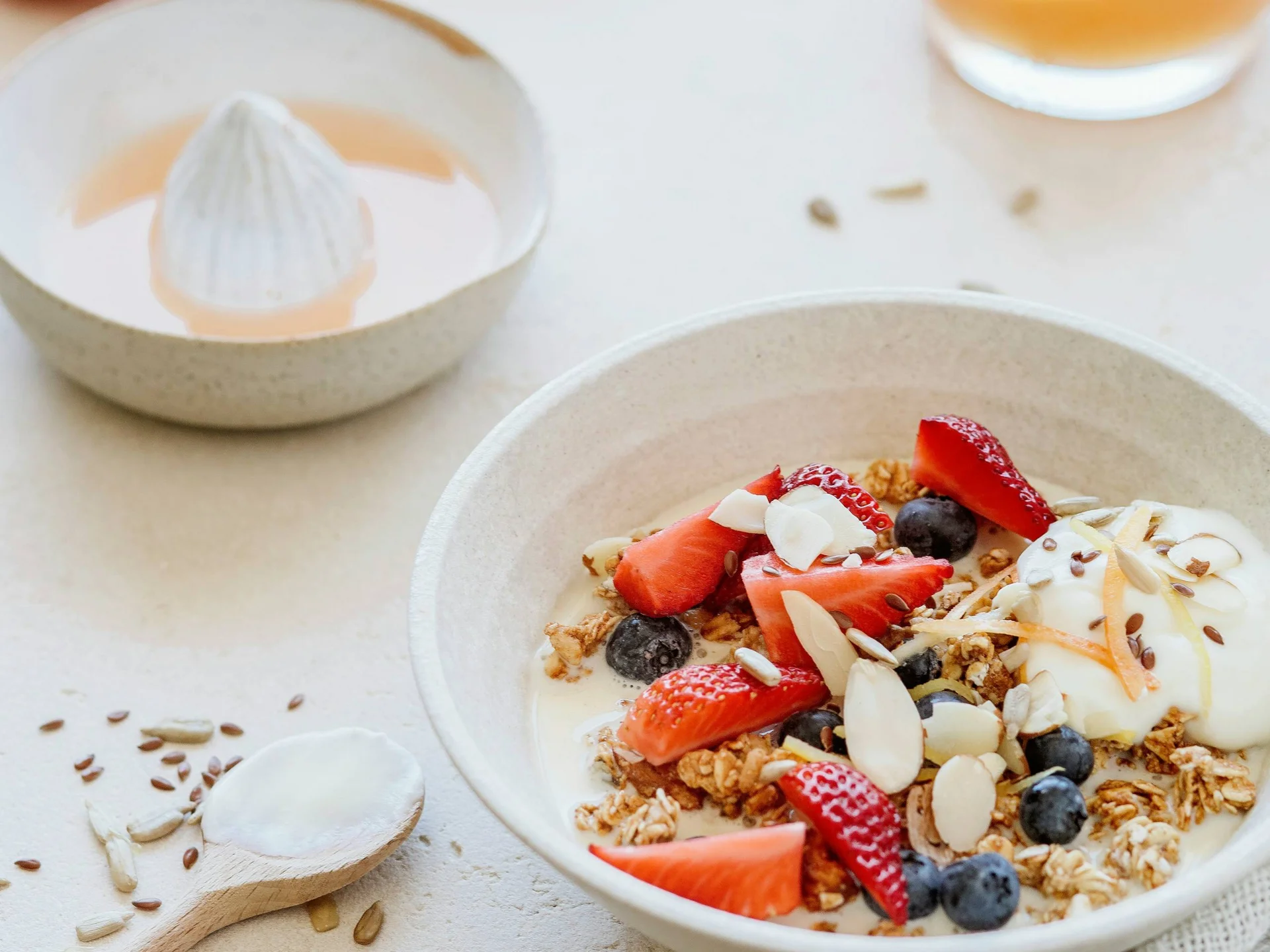 Die Bilder aus dem Hotel Salnerhof Schale mit Müsli, Joghurt, Erdbeeren und Heidelbeeren auf hellem Tisch