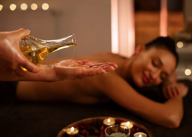 Kellner mit Inkasso Massageöl wird auf die Hand eines Masseurs in einem Spa gegeben