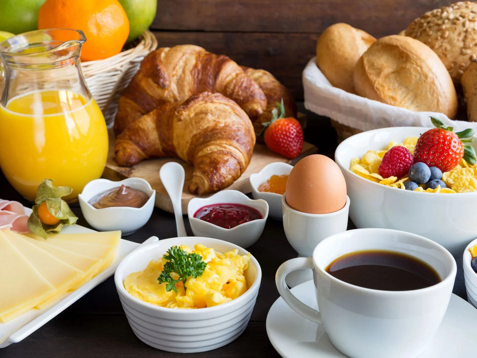 Die Bilder aus dem Hotel Salnerhof Frühstückstisch mit Croissants, Kaffee, Orangensaft, Eiern, Käse und frischem Obst