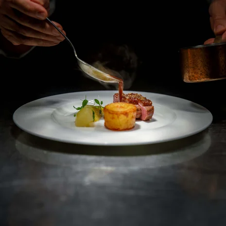 Ihr liebstes Restaurant in Ischgl Soße wird auf ein fein angerichtetes Gericht mit Fleisch und Beilage gegossen