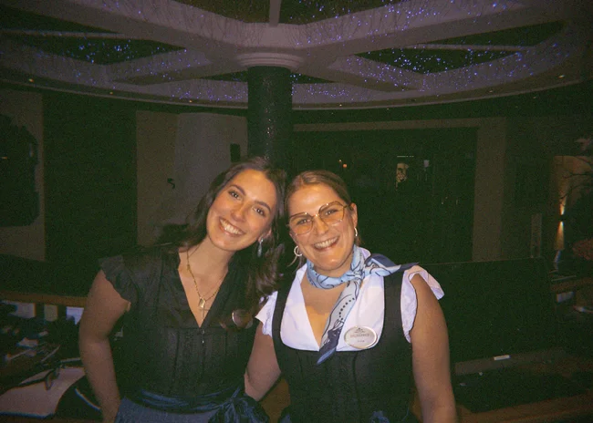 Dein Job im Salnerhof Zwei lächelnde Frauen in traditioneller Kleidung in einem dunklen Raum
