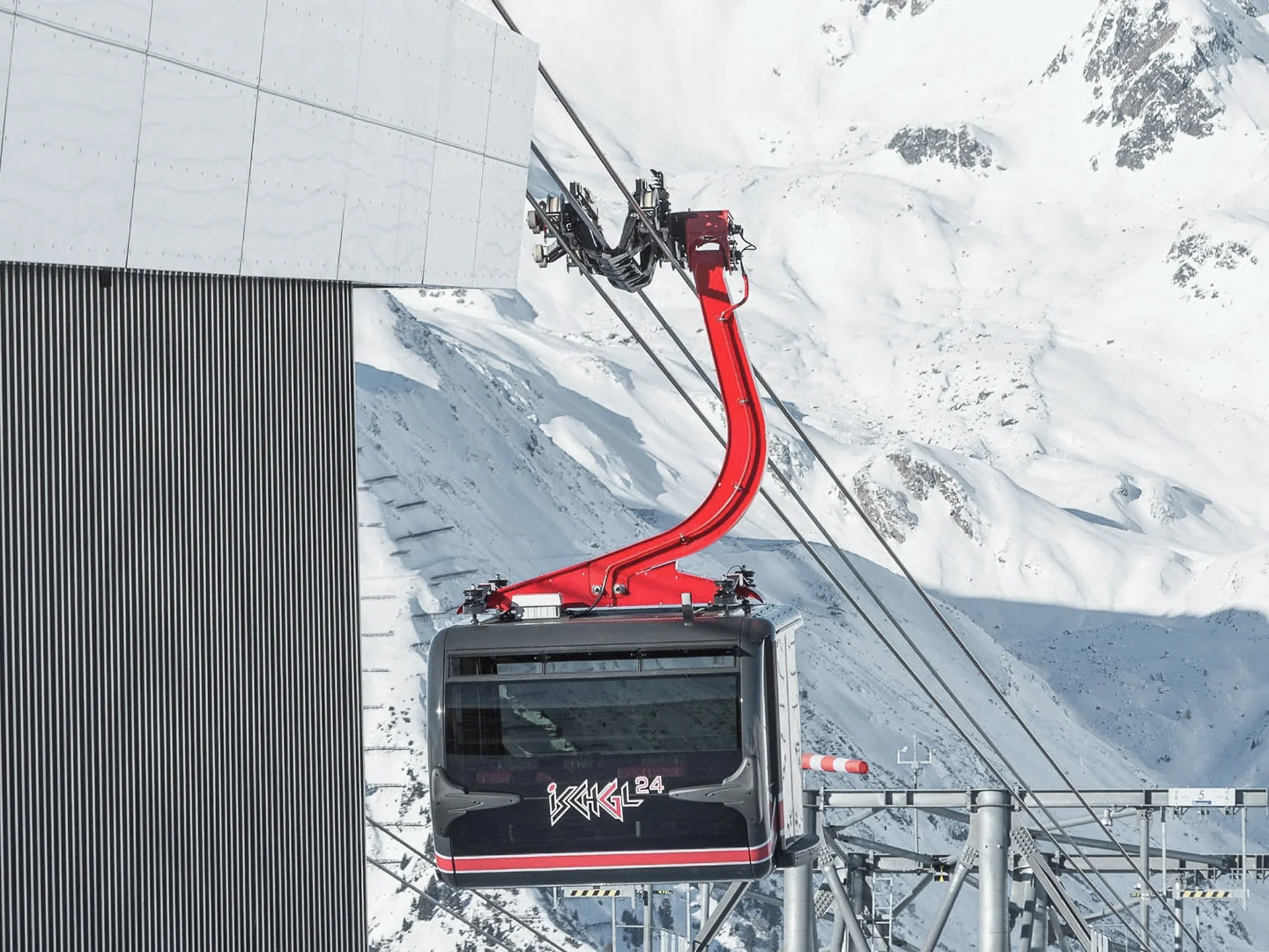 Die Bilder aus dem Hotel Salnerhof Schwarze Seilbahn mit rotem Arm an einer Bergstation im Schnee