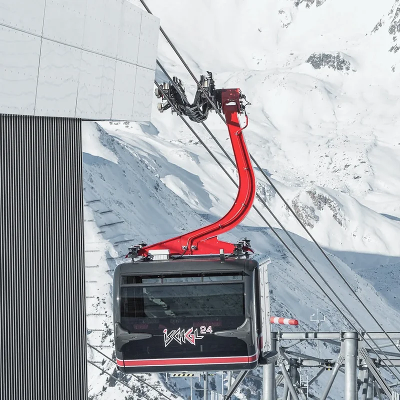 Ihr Skihotel in Ischgl Schwarze Seilbahn mit rotem Arm an einer Bergstation im Schnee