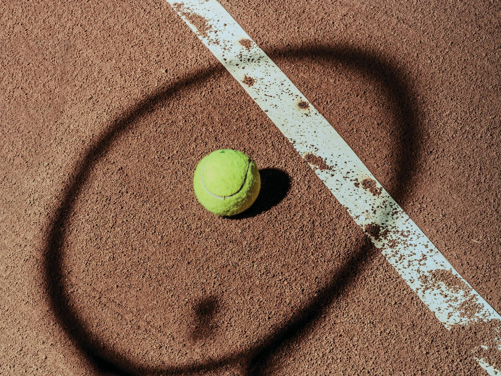 Pictures from Hotel Salnerhof Shadow of a tennis racket and a tennis ball on a clay court