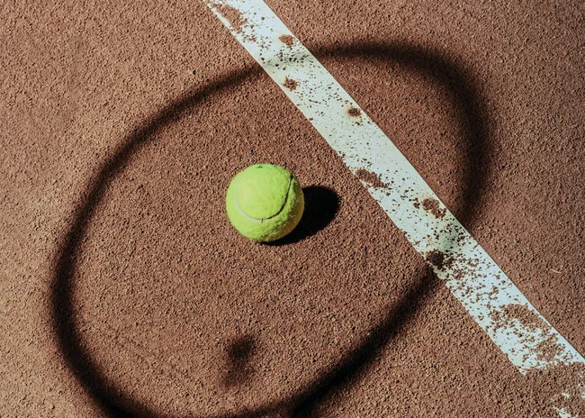 Ihr Sommer im Paznaun im Wander- und Bike-Hotel in Ischgl Schatten eines Tennisschlägers und ein Tennisball auf einem Sandplatz