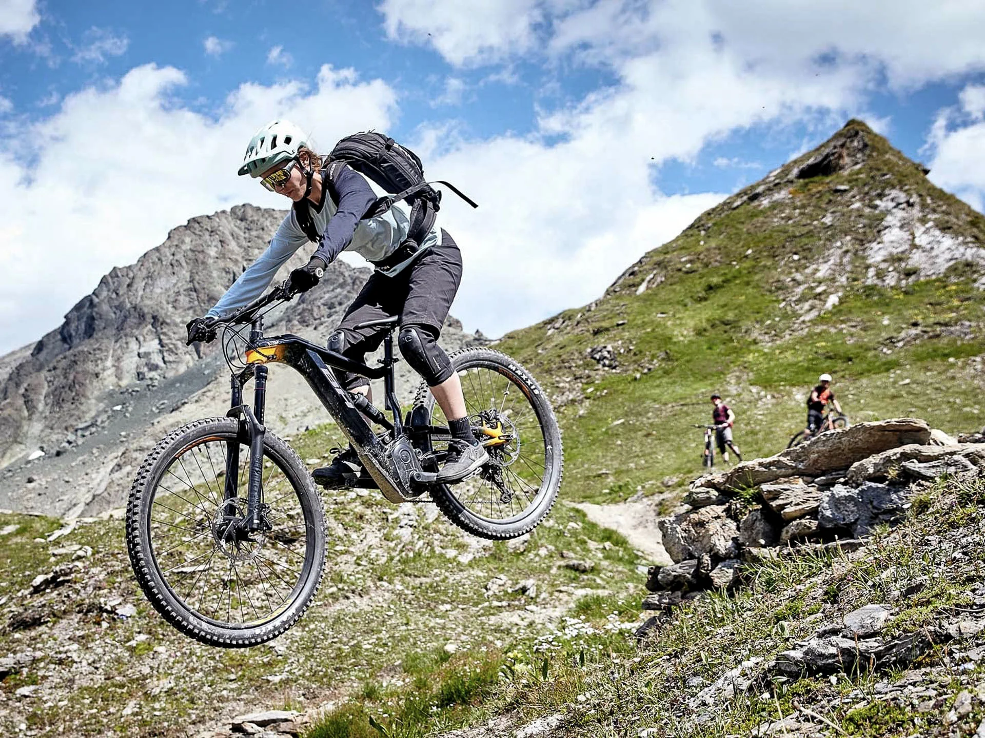 Die Bilder aus dem Hotel Salnerhof Mountainbiker springt im alpinen Gelände mit Bergen im Hintergrund