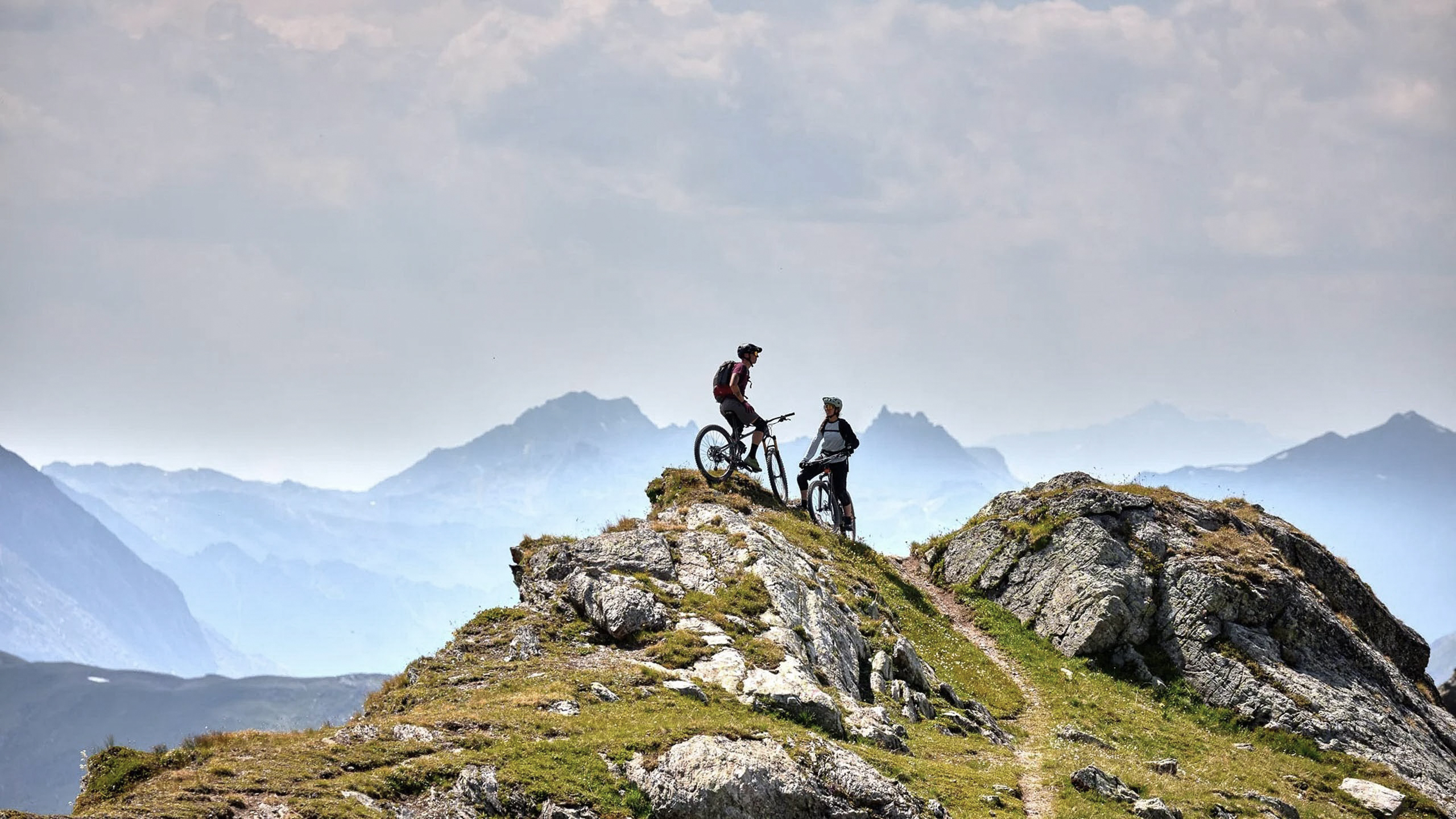Die Bilder aus dem Hotel Salnerhof Zwei Mountainbiker stehen mit ihren Fahrrädern auf einem felsigen Berggipfel
