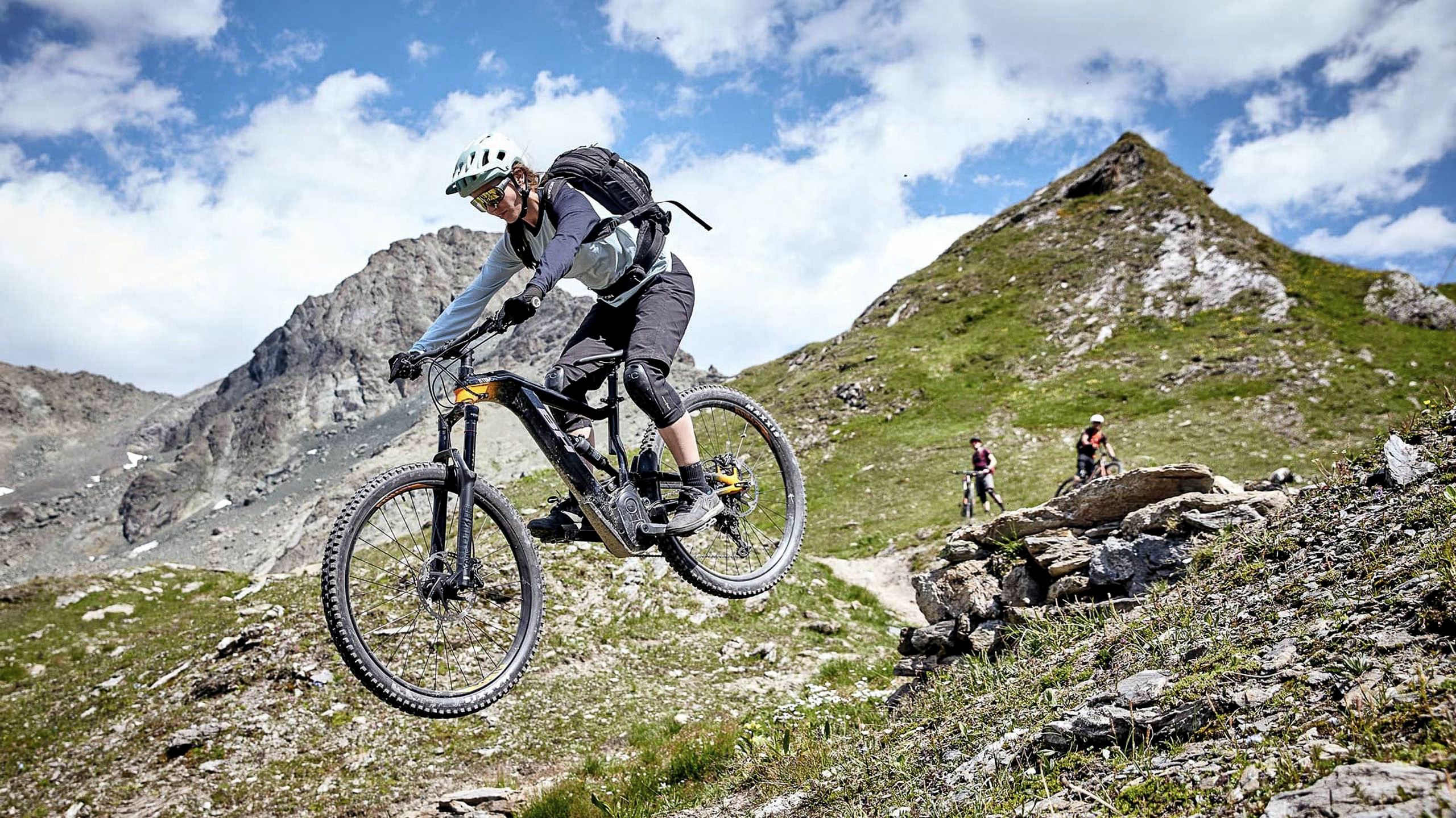 Die Bilder aus dem Hotel Salnerhof Mountainbiker springt im alpinen Gelände mit Bergen im Hintergrund