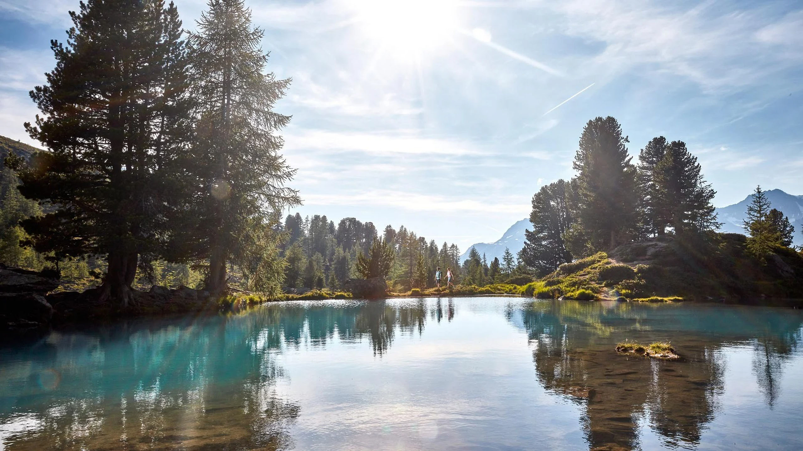 Die Bilder aus dem Hotel Salnerhof Sonniger Bergsee mit Bäumen und klarer Spiegelung im Wasser