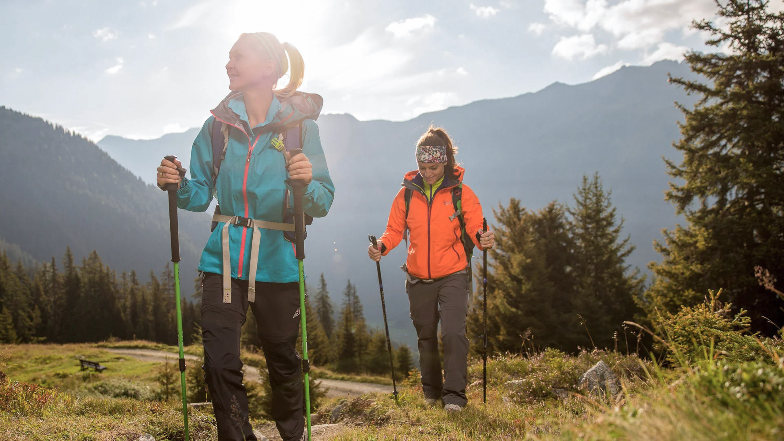 Die Bilder aus dem Hotel Salnerhof Zwei Frauen wandern mit Trekkingstöcken in den Bergen bei Sonnenschein