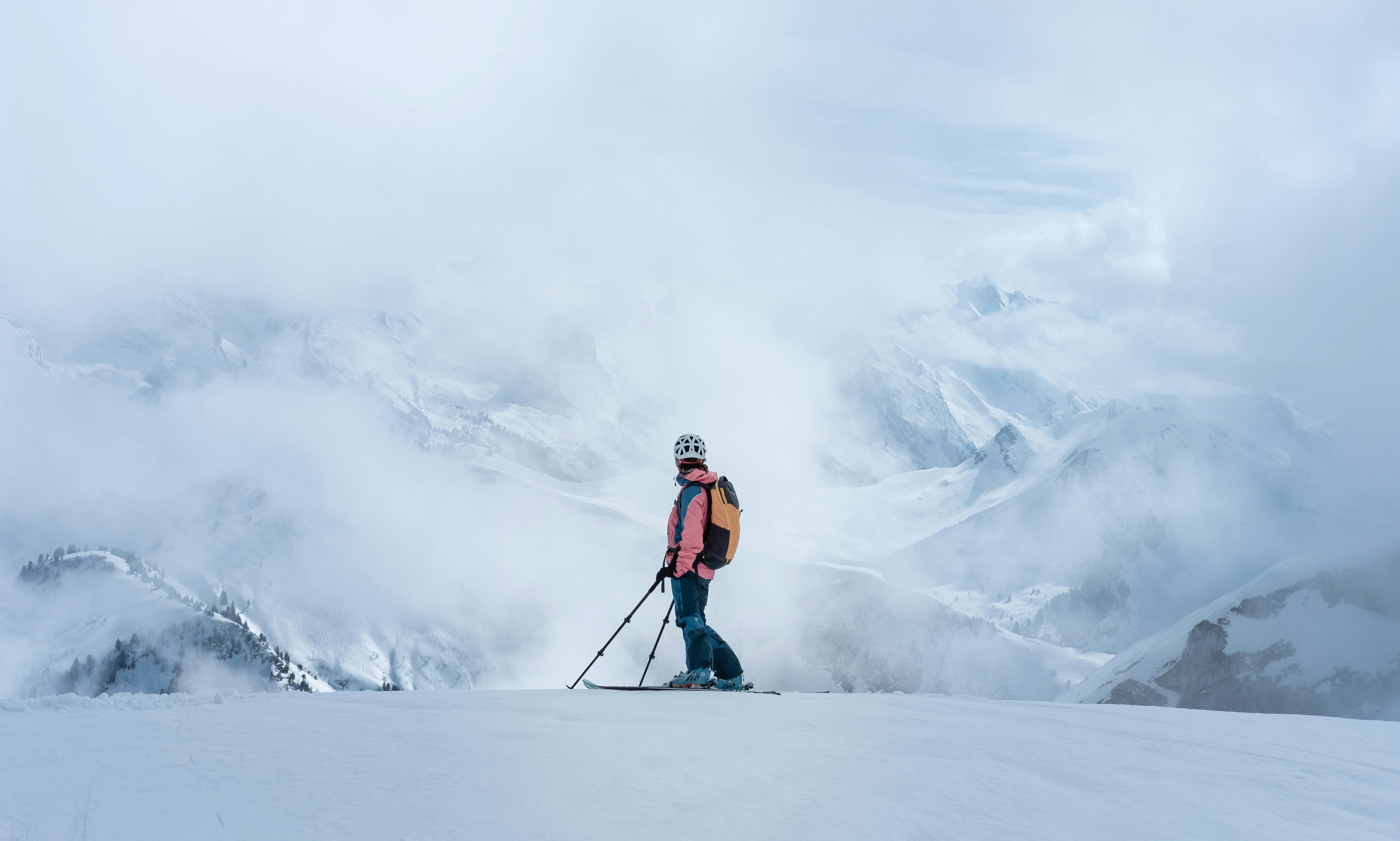 Die Bilder aus dem Hotel Salnerhof Skifahrer mit Helm und Rucksack auf verschneitem Berg vor nebligen Bergen